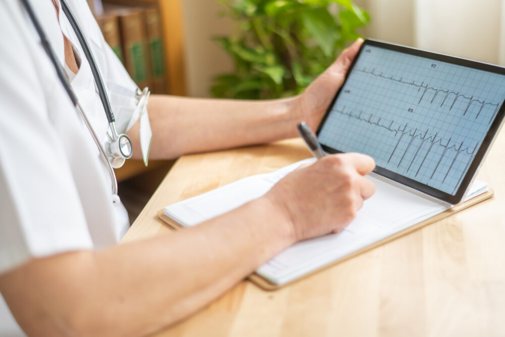 Clinician reviewing ECG readings on a tablet